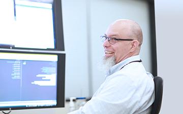 Defense customer sitting at computer smiling